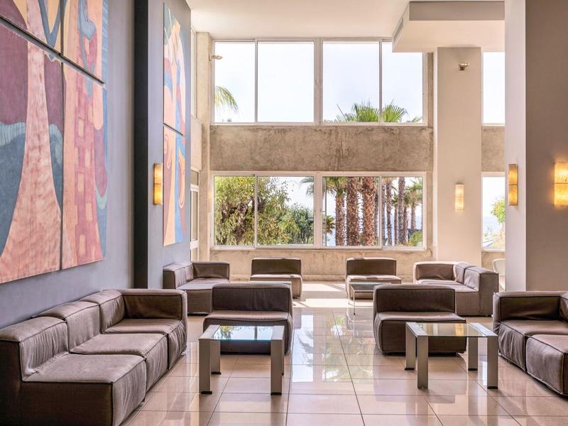 Modern eingerichteter Hotel-Lobbybereich mit Ledersofas und großen Fenstern.