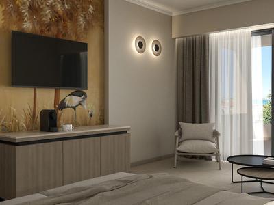 Helles Hotelzimmer mit großem Fenster, grauem Sessel und Wanddeko neben TV.