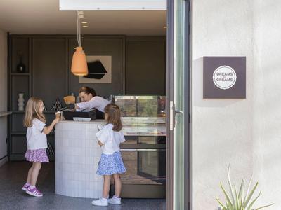 Tres niños están junto a un mostrador moderno de recepción en una zona luminosa del hotel.
