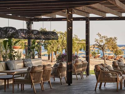 Lounge coperta con posti a sedere accoglienti e vista sulla spiaggia e sul mare.
