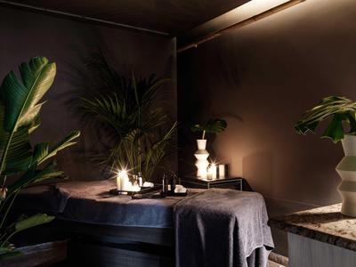 Tavolo illuminato con candele e piante in un ambiente interno elegante