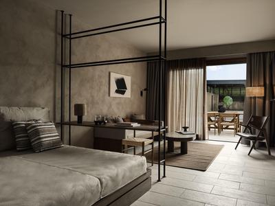 Camera d'hotel moderna con letto grande, zona salotto e accesso a una terrazza con mobili da giardino.