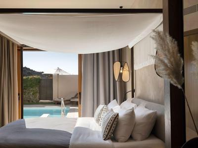 Una camera moderna con vista su una piscina e montagne sullo sfondo.