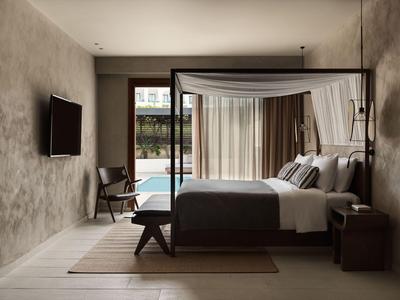 Camera d'hotel moderna con letto a baldacchino, TV e vista sulla piscina attraverso grandi finestre.