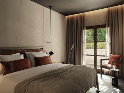 Habitación de hotel acogedora con cama grande, cortinas y acceso a balcón con vista verde.