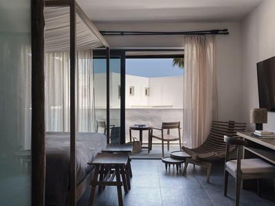 Habitación de hotel moderna con acceso a balcón equipado con sillas y mesa.