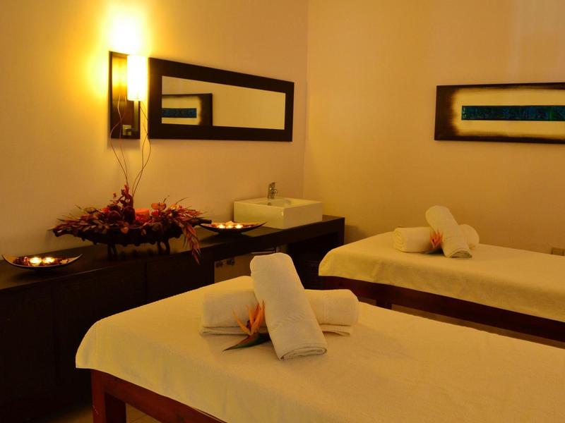 Gemütlicher Wellnessraum mit zwei Massagebetten und warmem Licht.