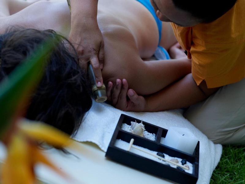 Massage im Freien auf einer Liege mit entspannender Umgebung im Garten.