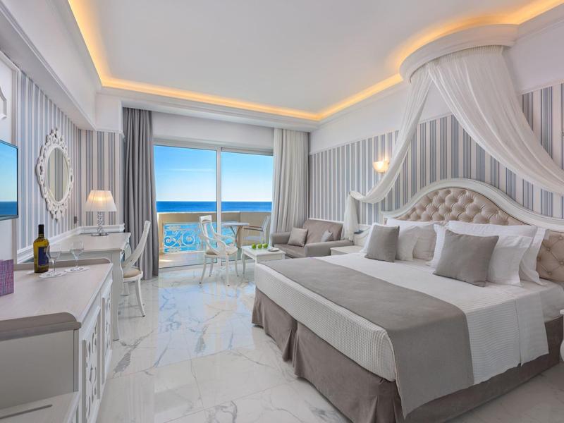 Moderne Hotelzimmer mit Meerblick, großem Bett und elegantem Interieur.