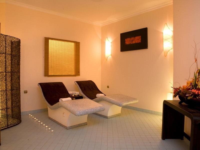 Gemütlicher Ruheraum mit zwei weißen Liegen und warmem Licht für entspannte Momente.