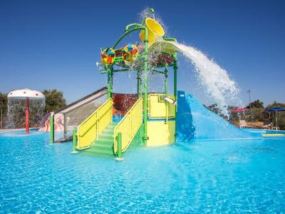 Bunter Kinder-Wasserpark mit Rutschen und spritzendem Wasser im hellen Außenpool.