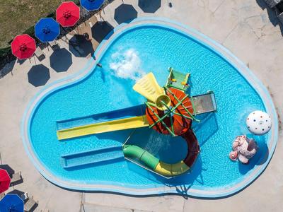 Ein kleiner Pool mit bunten Wasserrutschen und roten Sonnenschirmen für den Urlaub.