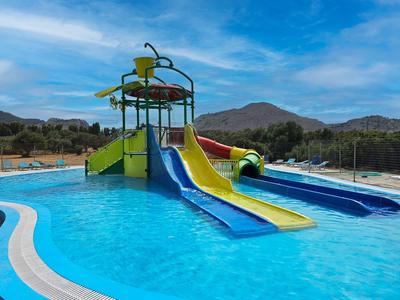 Waterpark met kleurrijke glijbanen in een zwembad met bergachtergrond