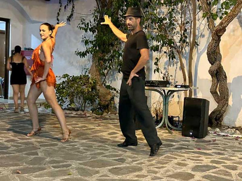 Stel voert dans uit op stenen terras met bomen en luidsprekers op de achtergrond.