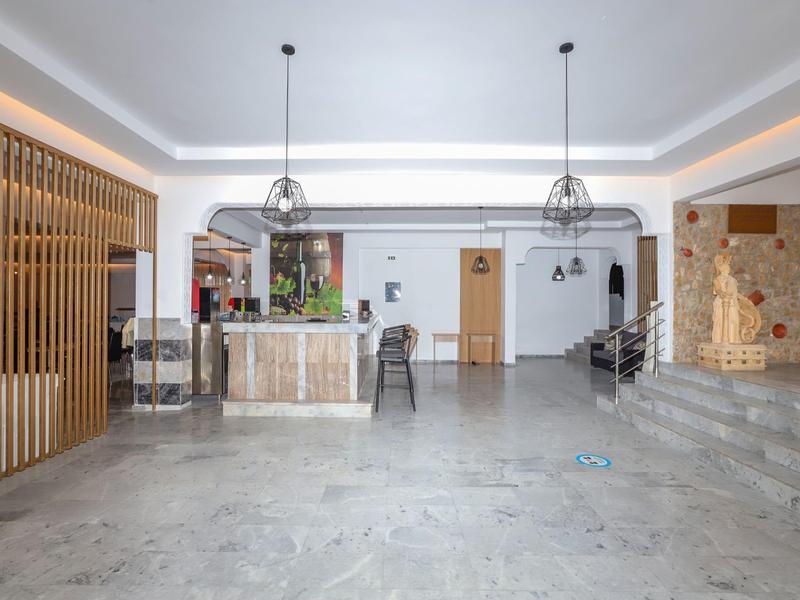 Ruime, lichte hotellobby met receptie en zithoeken.