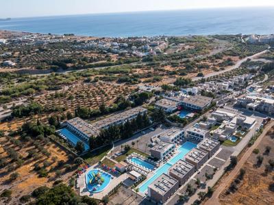 Luftaufnahme eines Hotelkomplexes mit mehreren Pools in einer Küstenlandschaft.