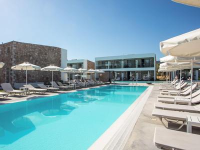 Moderner Hotelpool mit Liegestühlen und Schirmen unter klarem Himmel.