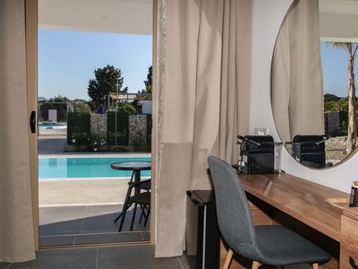 Moderner Innenraum mit Schreibtisch und Blick auf Pool im Freien.