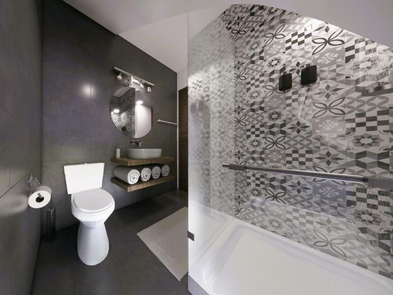 Modernes Badezimmer mit weißer Toilette, Marmor-Waschbecken und gemusterten Fliesen in Grau.