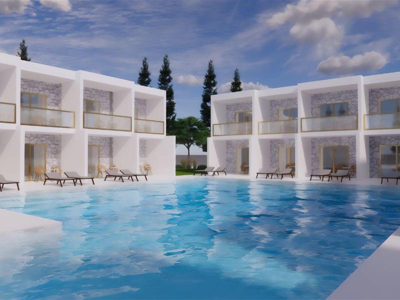 Moderner Hotelpool mit klarem Wasser, Liegestühlen und weißen Gebäuden unter blauem Himmel.