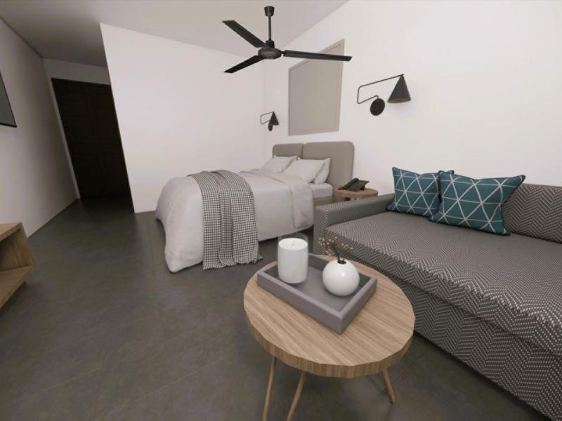 Kleines Zimmer mit grauem Sofa, rundem Holztisch, Bett und Wand-TV, schlicht und minimalistisch eingerichtet.