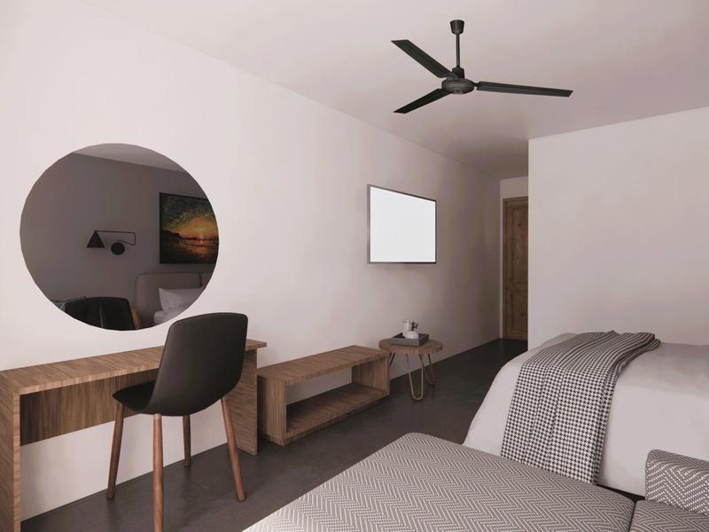 Helles Zimmer mit zwei Betten, rundem Spiegel, Holzschreibtisch, schwarzem Stuhl und Deckenventilator.