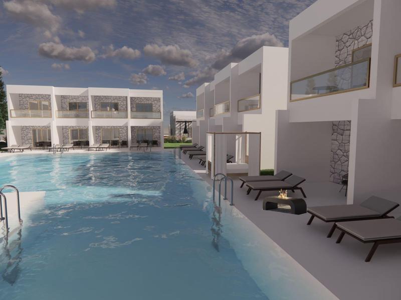 Moderner Hotelpoolbereich mit Liegestühlen und mehrstöckigen weißen Gebäuden bei bedecktem Himmel.