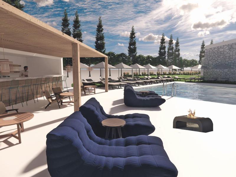 Moderner Außenpool mit blauen Liegesesseln und Sonnenschirmen vor einem Holzpavillon.