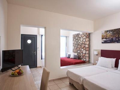 Helles Hotelzimmer mit zwei Betten, Schreibtisch und großem Spiegel an der Wand.