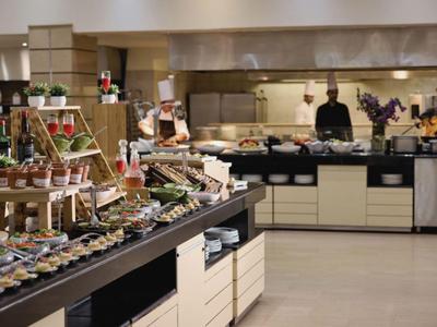 Buffetbereich mit vielfältigen Speisen und Küchenpersonal im Hintergrund.