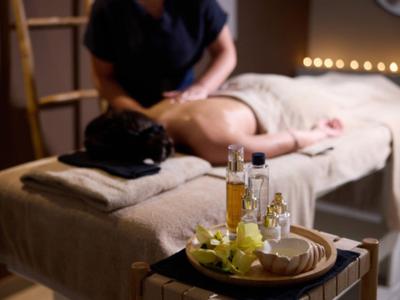 Entspannende Massage in einem gedämpft beleuchteten Spa-Raum mit Aromatherapie.