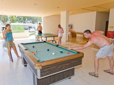 Personen spielen Billard in einem hellen Raum eines Hotels oder Freizeitzentrums.