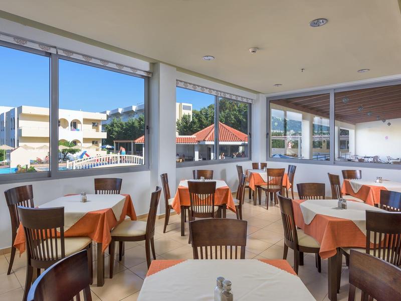 Bright dining area with tables and chairs, large windows offering city and mountain views.
