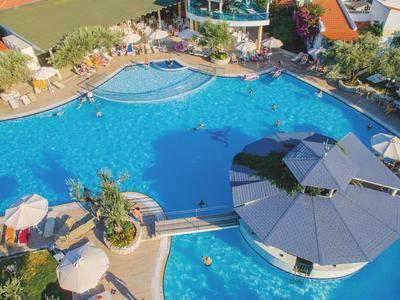 Großer Hotelpool mit runden Sonnenschirmen und Poolbar im Außenbereich