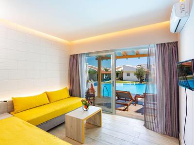 Nowoczesny salon z żółtymi sofami, szklanymi drzwiami prowadzącymi do basenu i strefy na zewnątrz.