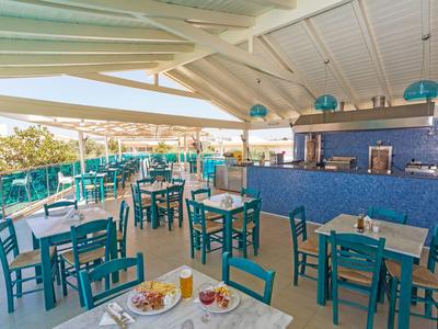 Offener Speisebereich mit blauen Stühlen und Tischen, Blick auf Außenbereich und Sonnenschutz