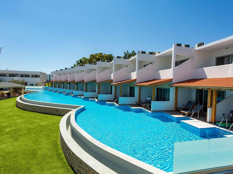 Nowoczesny ośrodek z pokojami przy basenie, niebieską wodą i zieloną trawą pod czystym niebem.