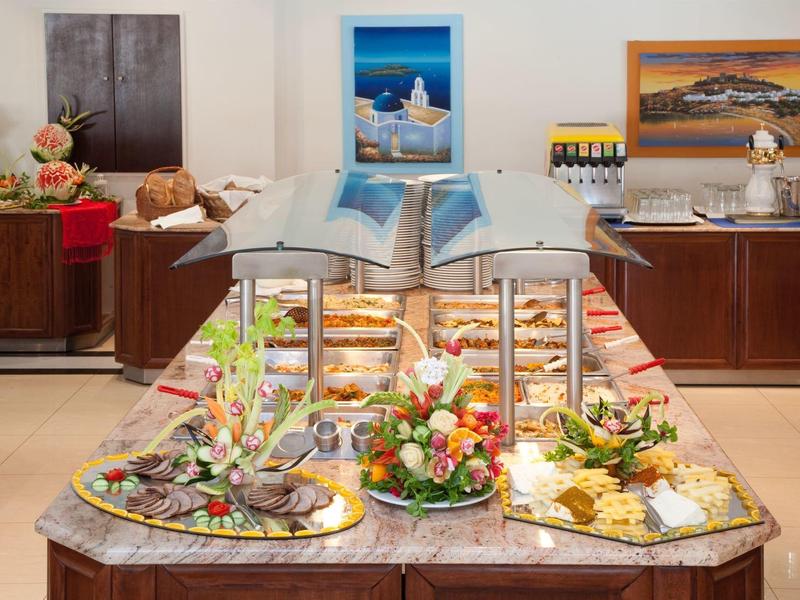 Bufet z różnymi przekąskami i sałatkami w dobrze oświetlonym pomieszczeniu jadalnym z ramkami na zdjęcia.