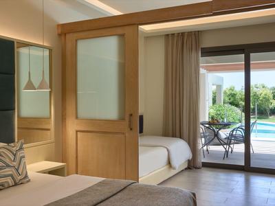 Habitación de hotel moderna con puerta corredera, vista a terraza y piscina, dos camas y colores neutros.