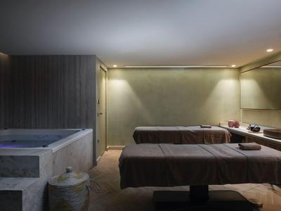 Sala de bienestar tranquila con dos camillas de masaje y luz tenue