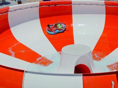 Große rote-weiße Wasserrutsche mit glatter, glänzender Oberfläche und Spiralform.