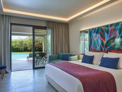 Helles Schlafzimmer mit großem Bett, buntem Wandbild und Blick auf Terrasse mit Pool.