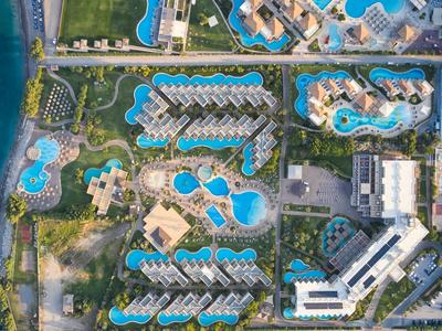 Vista aérea de un resort con varias piscinas y edificios junto al mar.