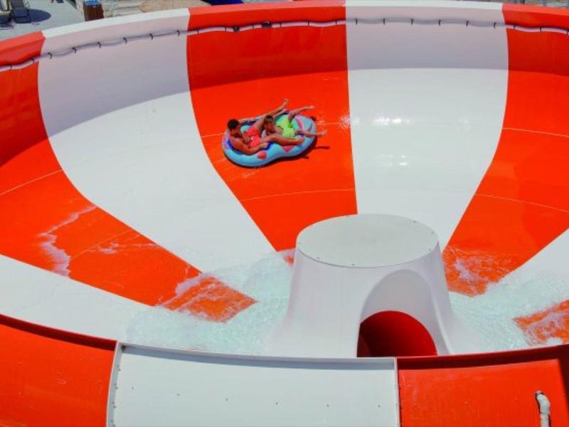 Große rote-weiße Wasserrutsche mit glatter, glänzender Oberfläche und Spiralform.