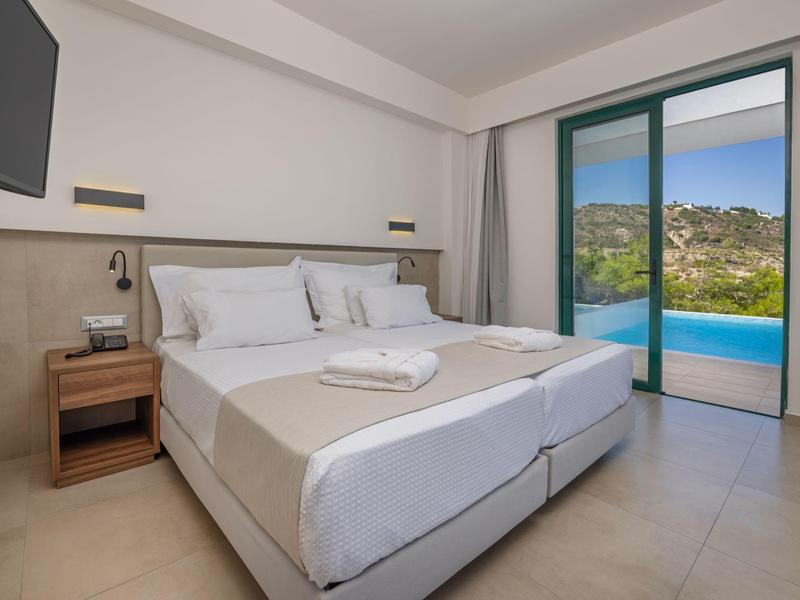 Schlafzimmer mit Doppelbett und Blick auf einen Pool und eine grüne Landschaft