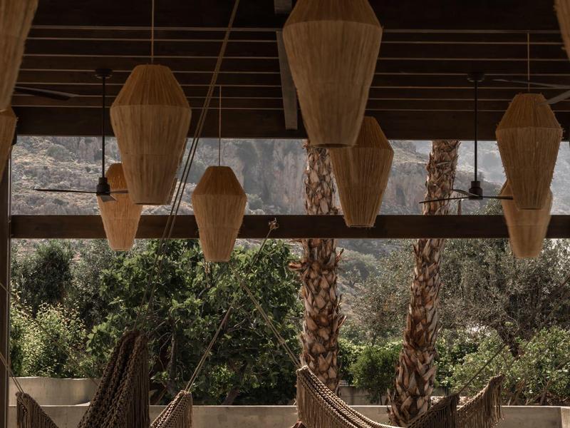 Amache sotto un tetto con grandi lampade sospese in materiali naturali.