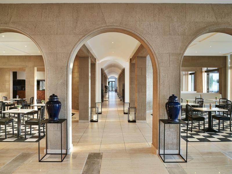 Corridoio dell'hotel con archi e aree salotto su entrambi i lati in design moderno