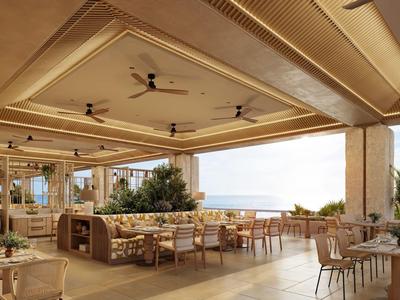 Espace restaurant ouvert avec mobilier moderne et vue sur la mer.