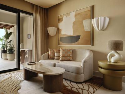 Salon confortable avec canapé beige, table basse et art mural moderne aux tons chauds.