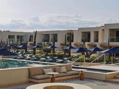 Piscine d'hôtel moderne avec chaises longues et foyer sous un ciel clair